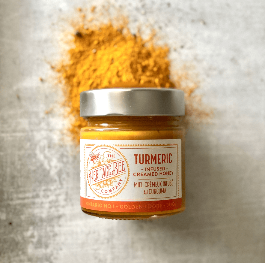Gourmet turmeric infused honey pictured with powdered turmeric.